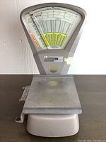 Front view of vintage Pitney Bowes postal scale showing full base and dial display with weighing platform, grey metal construction