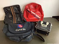 Four different bags displayed against a white wall on a flat surface to show the full lot.