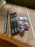 All curtain rods and other items displayed on a couch, including two boxed Eclipse tension rods, assorted metal rods, plastic bracket, and the steamer.