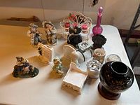 View of various figurines including Lipper & Mann and Boyds Bear, candle holders, glassware and decorative items on table.