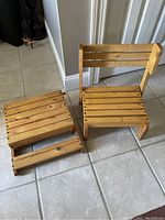 Photo of two wooden children's chairs, one upright, one folded flat as a step stool, on tiled floor.