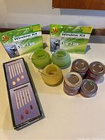 Duck Window Insulating Film Kits, citronella candle holders, and small citronella candles on table