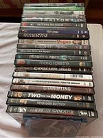 Photo of DVDs and VCR tapes stacked on a white cloth showing titles and cases