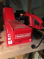 Photo showing Craftsman corded hedge trimmer with red handle alongside retailer packaging.