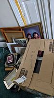Box and pile of assorted picture frames and photo album