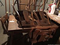 Vintage solid wood rectangular table with four wooden chairs stacked on top, showing overall condition and size.