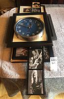 Framed clock with blue face and photos of blues musicians styled as film strips with black frames