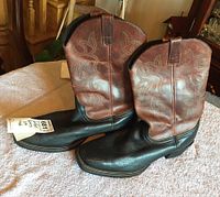 Pair of men's Red Head cowboy boots in black and brown leather with tooled decorative design on shaft and toe. Size 11.