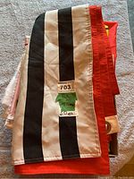 Close-up photo of a folded black and white striped flag with a label showing the lot number and details.