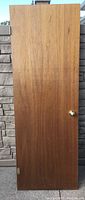 Front view of mahogany veneer door showing wood grain and brass doorknob