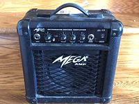 Front view of the Mega GL-15 guitar amplifier showing control panel and handle on top.