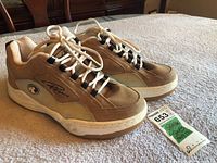 Front side angle view of Ripzone men's sneakers on carpeted surface with size tag next to shoes.