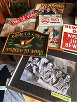 Lot of framed charcoal drawing and vintage signs including 'Born to Golf Forced to Work', 'No Smoking', 'No Se Fuma', The Three Stooges themed items, and others.