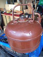 Vintage Eagle round metal gas jerry can with screw cap and top handle, reddish-brown finish