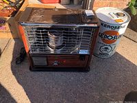 Front and slightly angled view of the Desa portable kerosene space heater with accompanying kerosene drum placed to the right.
