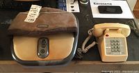 Both items together showing the Homedics foot massager with fabric cover and beige vintage phone on a table.