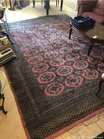Full view of the large wool area rug showing the repeating octagonal pattern and the surrounding room context.