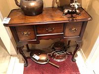 Front view of Hekman vintage hallway table with three drawers and brass handles. Table surface shows wood grain and slight wear.