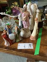 Photo showing various angel and female figurines including porcelain, ceramic, wood, and glass varieties arranged on a wooden surface