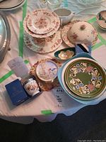 Overall photo showing the collection of plates, Royal Worcester egg coddler with box and instruction card, gravy boat, mini bowls, and assorted decorative plates.