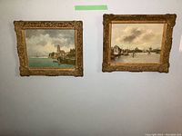 Two framed oil paintings on board hung side by side on a wall, showing harbour scenes with ornate gold frames.