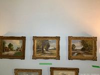 All three framed paintings on wall, arranged in a row
