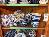 Top shelf showing stacked plates and a few decorative items with blue and white patterns.
