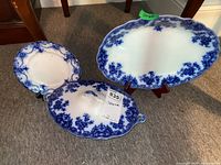 Three-piece blue and white serving set on display including plate, covered dish, and platter.
