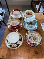 All six teacup and saucer sets arranged on wooden table