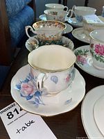 Multiple Royal Albert, Elizabethan, Queen Anne, and Royal Standard teacups and saucers with floral and gold detail designs.