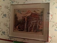 Framed watercolour artwork showing a mill on a cliff with water cascading down, part of the landscape includes trees and distant mountains under a partly cloudy sky.