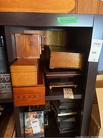 Shelving unit with several stacked wooden boxes, mostly medium-sized with dovetail joints and polished wood finish.