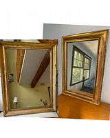 Two gold framed antique mirrors shown side by side with visible wear on the frames.