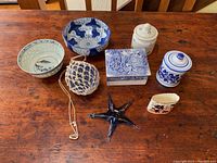 Overview of the lot showing blue and white decorative items including bowls, covered boxes, cobalt blue glass starfish, glass ball in net, and a small floral ceramic piece.