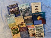 Photo shows all 11 books arranged on a soft surface, titles visible, varying sizes and styles, covering Cape Cod and Islands themes.
