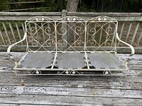 Full view of the white midcentury wrought iron sofa frame showing overall condition, rust patches, and scroll back metal design.
