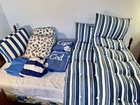 Photo showing two blue and white striped chaise lounger chair pads, two Cape Cod towels folded