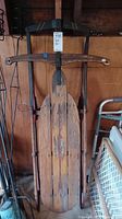 Front view of the Flexible Flyer wooden sled showing the wooden slats, metal runners, and steering handle.