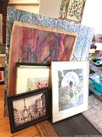Six pieces of wall art stacked together including abstract painting, cityscape print, and nature image