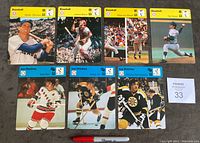 Full lot of 7 oversized 1977 Editions Rencontre sports cards, 4 baseball and 3 hockey, arranged in two rows on a carpeted surface with a Sharpie pen for scale.
