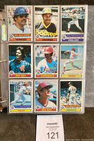 Front view of 9 baseball cards in plastic binder pages featuring Reggie Jackson (Yankees), Dave Winfield (Padres), Pete Rose (Phillies), Dennis Eckersley (Red Sox), Lou Brock (Cardinals), Tom Seaver (Reds), Johnny Bench (Reds), Carl Yastrzemski (Red Sox), Jim Palmer (Orioles). Cards show original gloss and good condition with some corner wear.