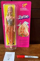 Front view of the Barbie doll in original sealed blister pack and pink backing card featuring Barbie and Mattel logos.