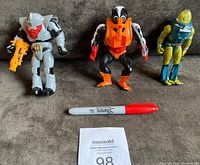 Front view of all three Masters of The Universe figures with a Sharpie marker for scale