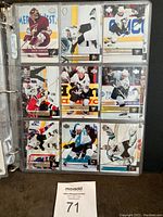 Page of hockey cards in plastic binder sleeve showing various players in game action.