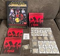 Lot overview showing black custom holder for 1994 NHL Hockey Greats gold plated coin set, 2 red Coca-Cola Olympic coin holders, and multiple coins in sleeves and plastic pouches arranged on fabric surface.