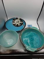 Photo of slag glass bowl and two ceramic dishes with different colors and designs.