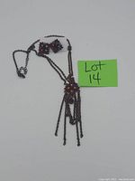 Photo showing vintage dark metal necklace with multi-colored stones, chain tassels, and matching earrings.
