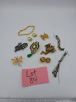 Clear view of all vintage costume jewelry pieces arranged with lot identification card