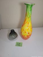 Two hand blown glass vases on white surface with lot number card