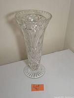 Front view of large vintage cut crystal vase with scalloped flared rim on round base showing detailed cut patterns.